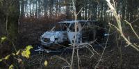 Der ausgebrannte Fluchtwagen, ein VW-Bus, steht in einem Waldstück in Liesten (Altmarkkreis Salzwedel).