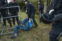 Polizei reißt Demonstranten an Kapuze zu Boden.