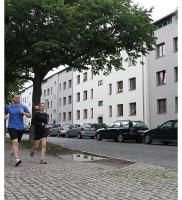 Jogger passieren die Mehringstraße in Magdeburg-Cracau. In diesem Stadtteil befinden sich hunderte Wohnungen der Baubecon-Gruppe. | Foto: Eroll Popova