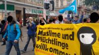 Wolfsgruß und R4bia-Gruß hinter Linkswende-Transpi