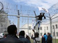 Ein Demonstrant versucht, die Absperrungen zu überklettern