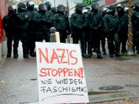 Polizeikräfte stehen in Göppingen hinter einem Plakat linker Gegendemonstranten. Rund 100 Rechtsextreme hatten sich zu einer Kundgebung versammelt. Foto: dpa