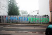 Graffiti am Zaun des Nazizentrums in der Odermannstraße 8