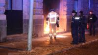 Der Einsatzleiter der Feuerwehr und Polizeibeamte vor dem brennenden Eingang der Bußgeldstelle der Polizei. Foto: Spreepicture
