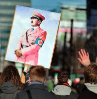 Bunt statt braun: Ein Gegendemonstrant trägt ein Plakat mit einem rosafarbenen Hitler-Bild am Rande eines Neonazi-Aufmarschs am Samstag in Magdeburg