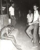 Singhalesische Schlägertruppe tanzen vor einem tamilischen Mann Kurze Zeit später überschütten sie ihn mit Benz und zünden ihn an.(Praxis der Stripping-Tamilen nackt, sie zu demütigen und zu töten ist eine ART in Sri Lanka)