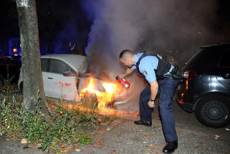 Alte Jakobstraße in Kreuzberg: Hier versucht ein Polizist zu löschen, doch die Flammen lodern immer wieder auf