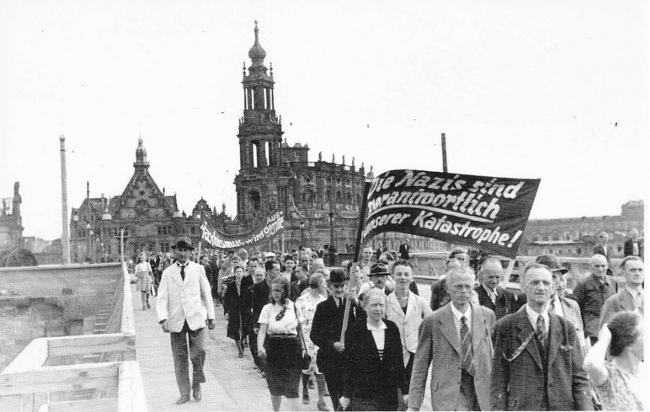 Demonstration der Dresdner KPD über die Augustusbrücke am 28. Juli 1945 - Transparent im Vordergrund: "Die Nazis sind verantwortlich an unserer Katastrophe!"