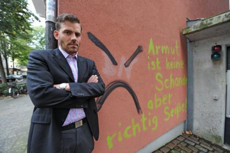 Falko Droßmann, Chef der SPD-Fraktion Mitte, vor der beschmierten Wand seines Wohnhauses in St. GeorgFoto: Laible