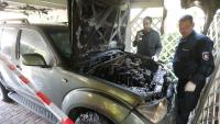 Brandermittler der Polizei sind im Einsatz, sichern Spuren am ausgebrannten Nissan
