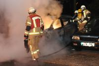 Feuerwehrleute beim Löschen eines brennenden Wracks in der Nacht zum 2. 10. 2014