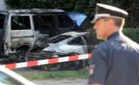 Ein ausgebrannter Sportwagen und ein Bus stehen im Sommer 2009 im Hamburger Stadtteil Eimsbüttel. 185 Autobrände zählte die Polizei der Stadt im vergangenen Jahr.
